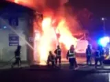 Un grupo de bomberos intenta apagar un enorme incendio en un almacén de Londres.