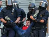 Efectivos de los Mossos d' Esquadra retiran a uno de los manifestantes concentrados junto al acceso a la oficina de la empresa de mensajería Unipost en Terrassa (Barcelona).