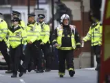 Bomberos y policías caminan junto a la estación de metro Parsons Green en Londres (Reino Unido).