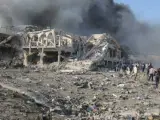 La gente se reúne en la escena de una explosión masiva frente al Hotel Safari en Mogadisci, la capital de Somalia, el 14 de octubre de 2017. Según los informes, al menos 85 personas murieron cuando una bomba de camión explotó en una calle transitada del centro de Mogadiscio.