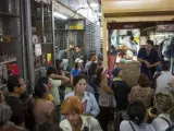 Un grupo de personas hace la compra en un mercado popular de Venezuela.