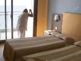 Una mujer limpia una habitación en un hotel de la costa.