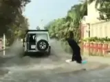 Una mujer vestida con un burka negro es arrastrada por un todoterreno mientras se desliza en una tabla de surf por una calle inundada de Arabia Saudita. Esta escena fue grabada desde un vehículo que vio la gran habilidad de la surfista a varios metros.
