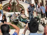 Varios turistas se fotograf&iacute;an junto al popular drag&oacute;n de trencad&iacute;s del Park G&uuml;ell de Barcelona.