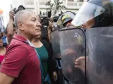 Manifestantes se enfrentan a la Policía, que impide el paso de una marcha en contra del indulto al expresidente de Perú Alberto Fujimori.