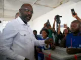 El candidato presidencial y exfutbolista George Weah (c), del Congreso por el Cambio Democrático (CCD), ejerce su derecho al voto en la segunda vuelta de las elecciones presidenciales en Monrovia (Liberia).