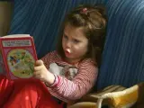 Una niña lee un cuento.