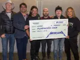 Imagen de la banda Metallica entregando el cheque a la Fundación Rais.