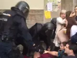 Policías antidisturbios actúan en un centro de Barcelona para evitar que se vote en el interior del colegio, durante el referéndum sobre la independencia de Cataluña suspendido por el Tribunal Constitucional.