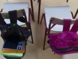 Dos mochilas en una clase de un colegio.