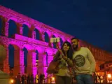 Una pareja se hace un 'selfie' ante el Acueducto de Segovia iluminado.