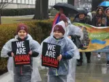 Dos niños sujetan pancartas en las que se lee "somos seres humanos", durante una marcha hacia el Capitolio, en Washington (EE UU), en contra de las políticas migratorias del presidente Trump.