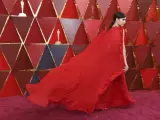 La actriz Sofia Carson hace volar su capa roja sobre la alfombra del mismo color, en la ceremonia de los Óscar 2018.