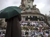 Una persona permanece frente al santuario improvisado en homenaje a las víctimas de los atentados perpetrados por el Estado Islámico (EI) el pasado 13 de noviembre, en la plaza de la República de París (2015).
