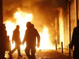 Contenedores incendiados en la calle Mesón de Paredes con la calle del Oso, en el barrio de Lavapiés.