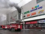 Equipos de bomberos combaten el fuego declarado en un centro comercial de la ciudad de Kemerovo, en Siberia (Rusia).
