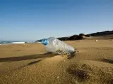 Botella de plástico en la arena de la playa.