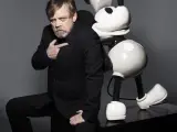 El actor de Star Wars señala a la figura de Mickey Mousee en la que está apoyado.