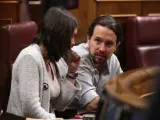 Irene Montero y Pablo Iglesias sentados en sus escaños en el Congreso.