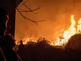 Unos vecinos observan como se acerca a sus casas el incendio forestal de Carballeda de Avia (Ourense).