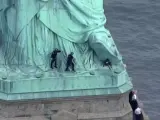 Dos policías en el momento de la detección de una mujer que se había encaramado al pedestal de la Estatua de la Libetad, en Nueva York (EE UU).