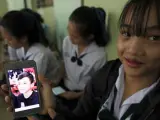 Una estudiante tailandesa muestra una fotografía de su compañero de clase Duangpetch Promthep, quien se encontraba atrapado en la cueva de Chiang Rai.