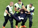 Miembros de seguridad sacan del campo a una espontánea al inicio de la segunda parte del partido Francia-Croacia.