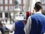 Un camarero sirve bebidas en una terraza.