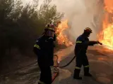 Bomberos tratan de extinguir un incendio en Grecia.