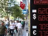 <p>Ciudadanos pasean junto a un centro de cambio de divisas en Estambul, Turquía.</p>