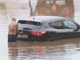 Coche inundado en una avenida.