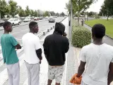 Un grupo de migrantes espera en la parte española del Puente de Santiago parta cruzar a Francia.