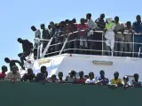 Un numeroso grupo de inmigrantes esperan para desembarcar del barco español Río Segura, a su llegada al puerto de Salerno, en Italia.