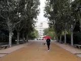Una persona se protege de la lluvia en Madrid.