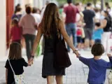 Una madre lleva a sus hijos al colegio.