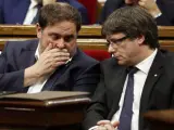 El expresidente de la Generalitat Carles Puigdemont (d) y el exvicepresidente Oriol Junqueras (i) en el Parlament. (EFE)