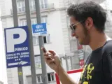 Un usuario conecta su teléfono móvil a la red wifi de la Plaza de Santo Domingo de Madrid.