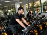 Dos j&oacute;venes hacen ejercicio en la bicicleta de spinning de MoveWatts.