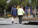 Dos personas paseando por un parque.