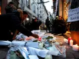 Ciudadanos encienden velas en el lugar donde falleció una de las víctimas en el atentado en Estrasburgo (Francia).