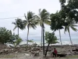 Un hombre permanece sentado entre las ruinas de viviendas tras el paso de un tsunami en el estrecho de Sonda.