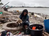Una mujer recoge pertenencias reutilizables entre los escombros en Labuan.