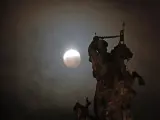 La luna llena durante la fase final del eclipse total, sobre una figura ecuestre del Ap&oacute;stol Santiago en la Plaza del Obradoiro