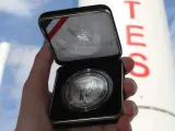 Una persona muestra una moneda de plata de cinco onzas que conmemora los 50 años de la llegada del hombre a la Luna.