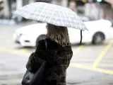 Imagen de archivo de una persona con paraguas por la lluvia.