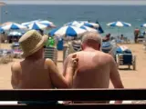 Dos ancianos toman el sol en la playa.
