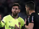 Messi conversa con un &aacute;rbitro durante un partido del Barcelona.