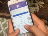 Un usuario, conectándose a la red social Facebook en un teléfono móvil.
