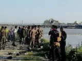 Varios soldados inspeccionan el lugar donde una barca volvó por exceso de pasajeros en el río Tigris, en Mosul (Irak).