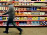 Un hombre pasea frente a una estanter&iacute;a en un supermercado.